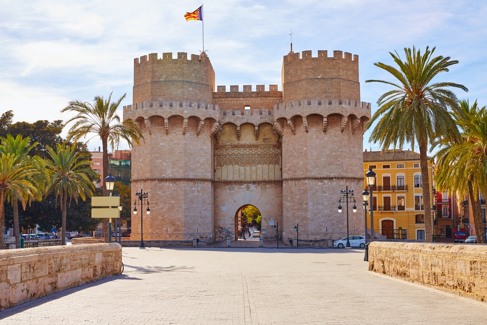 vrijwel lege straat met aan het einde de Torres de Serranos in Valencia