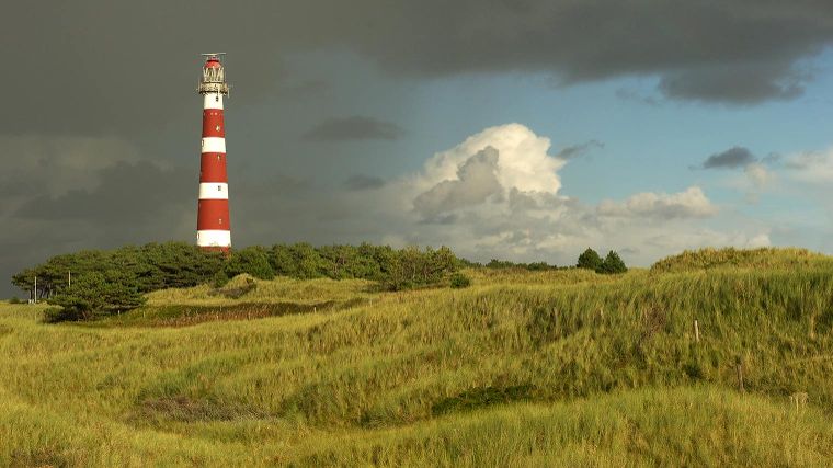 de vuurtoren van Ameland gezien vanuit de duinen op een onstuimige dag