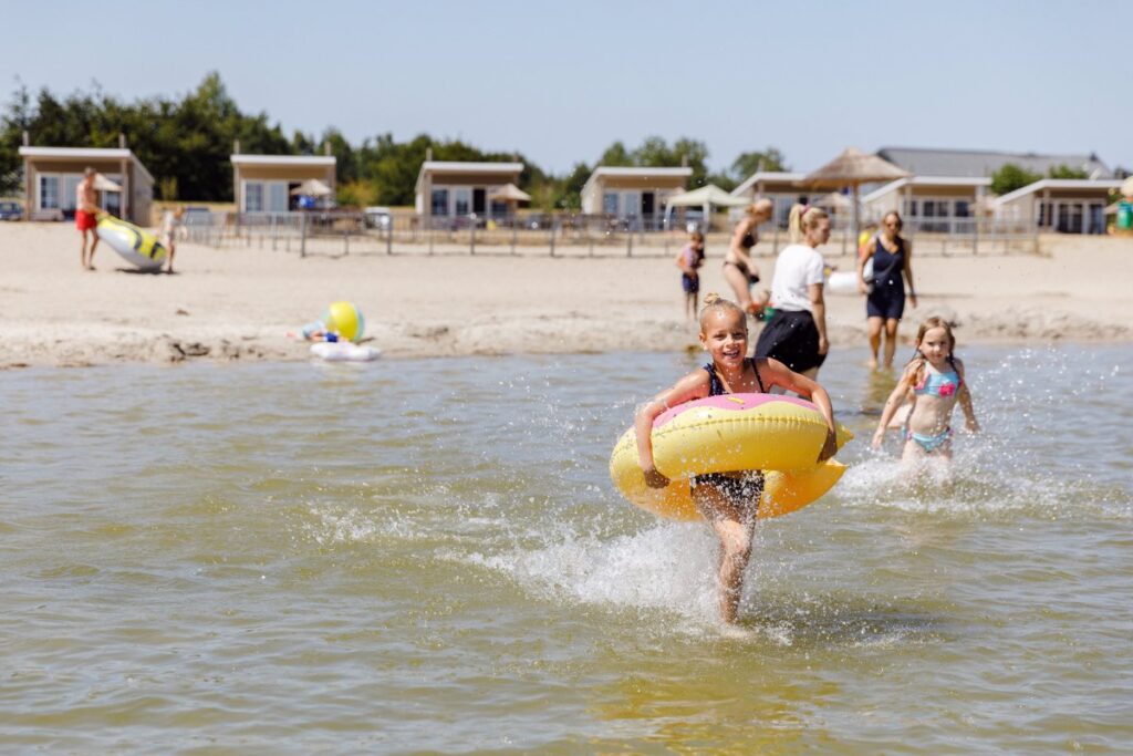 meisje dat met een zwembad een recreatieplas in rent op vakantiepark RCN de Zeewolde