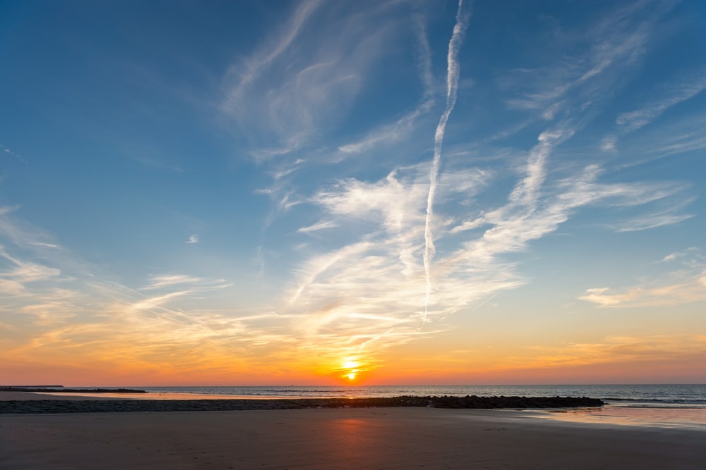 ondergaande zon op een blauwe dag in de Belgische kustplaats Bredene