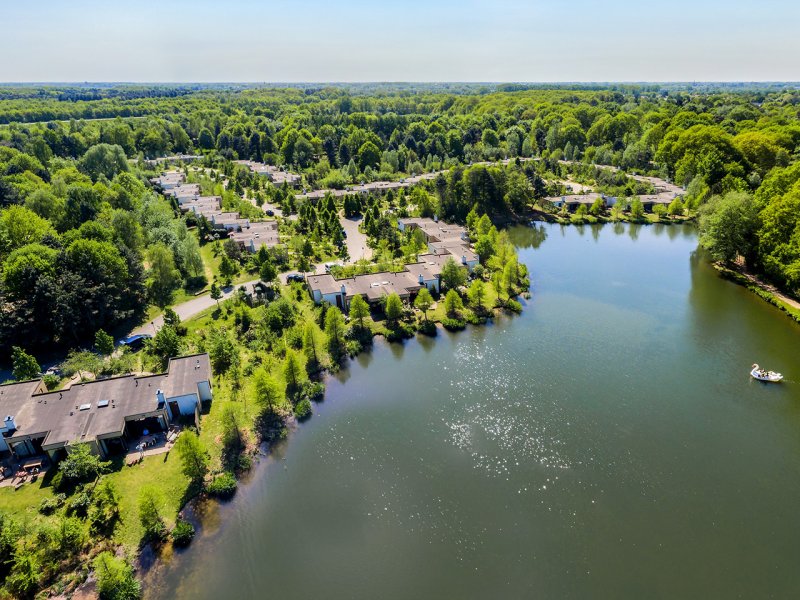 luchtfoto van Center Parcs Het Heijderbos met rechts een groot meer met een waterfiets in de vorm van een zwaan