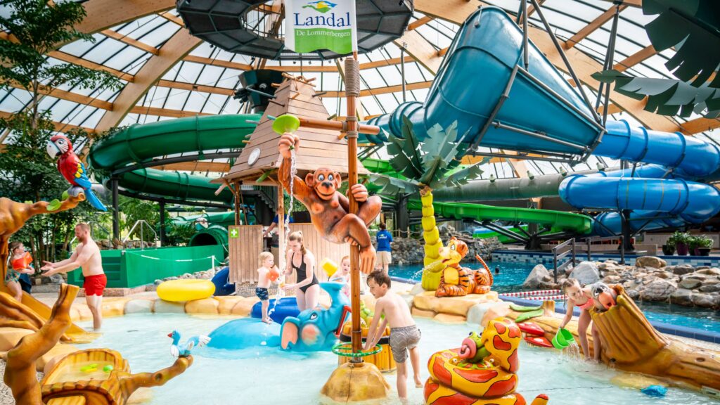 kindern die spelen in een kinderbad met dierenfiguren zoals een aap en papagaai in het tropisch zwembad op vakantiepark Landal De Lommerbergen in Limburg