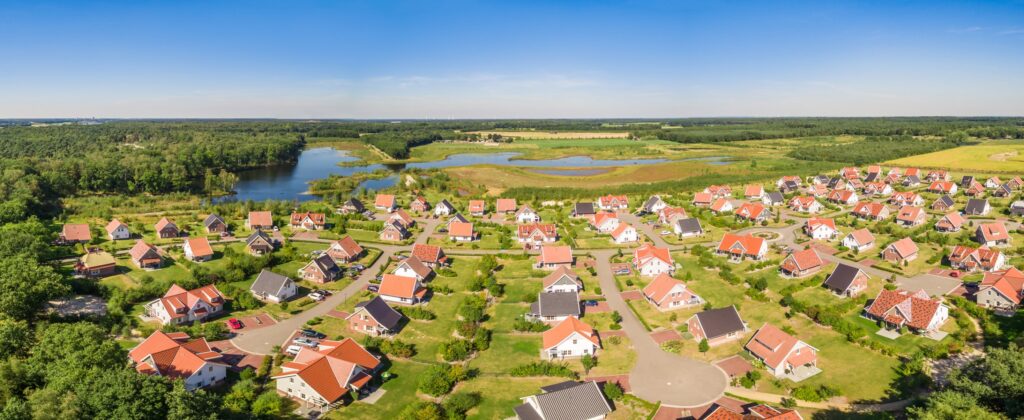 vakantiehuisjes met oranje daken gezien van bovenaf op Roompot Résidence Klein Vink gelegen aan het water