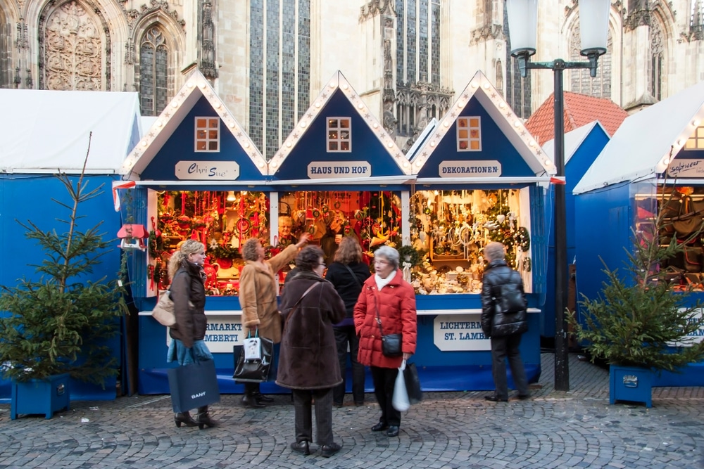kerstmarkt met blauwe kraampjes en dames op voorgrond in Münster