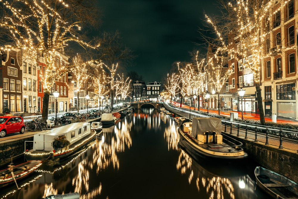 bootjes met kerstverlichting in een kanaal in Amsterdam