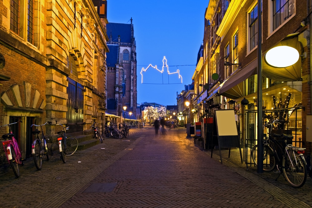 met kerstlichtjes versierde bomen aan het eind van een straat tijdens schemering in Haarlem