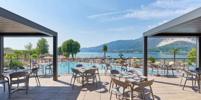 het lege terras van Camping Isoline met uitzicht op het zwembad en het Lago Maggiore