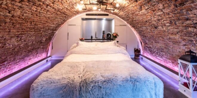opgemaakt bed midden in een werfkelder in het eenkamerhotel UKI in Utrecht