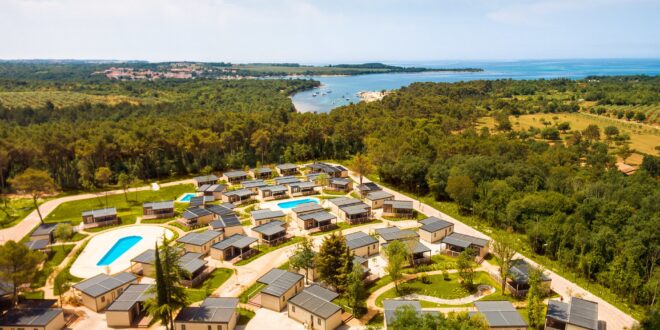 camping met stacaravans en driezwembaden in Kroatië, met op de ahtegrond de zee en enkele bootjes, gezien van bovenaf